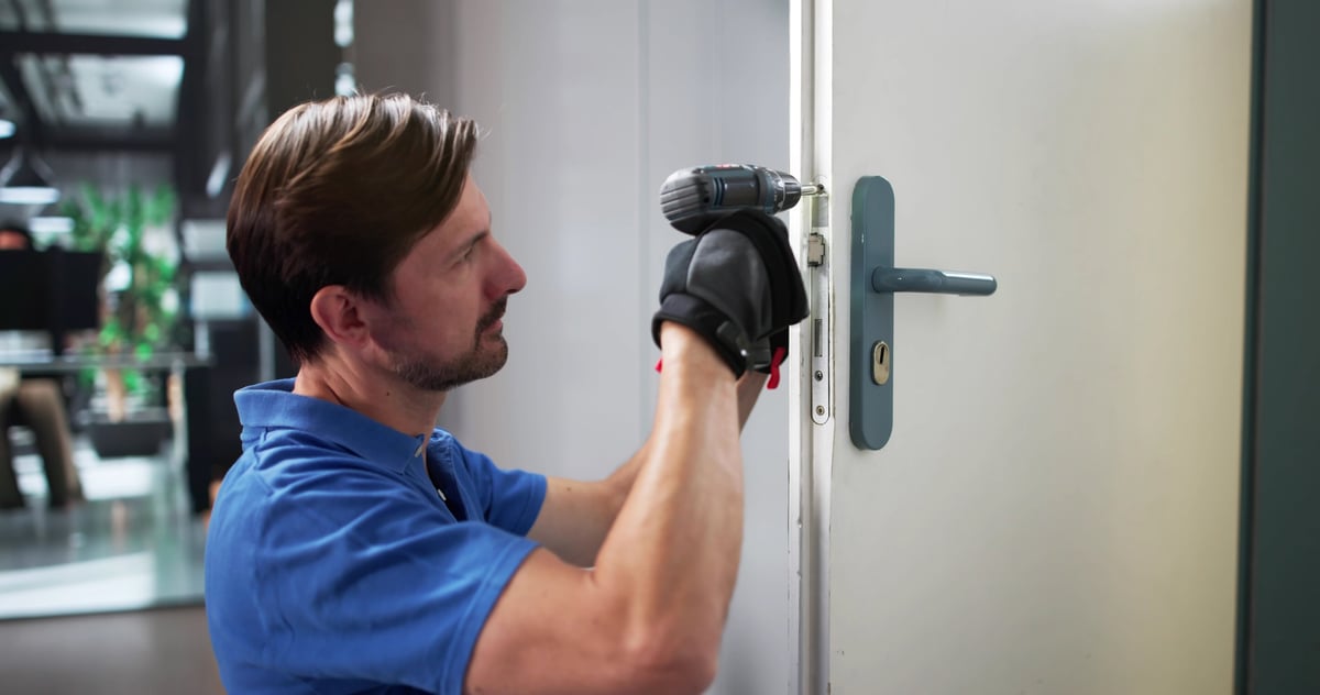 Professional locksmith expertly installing and repairing a security door lock